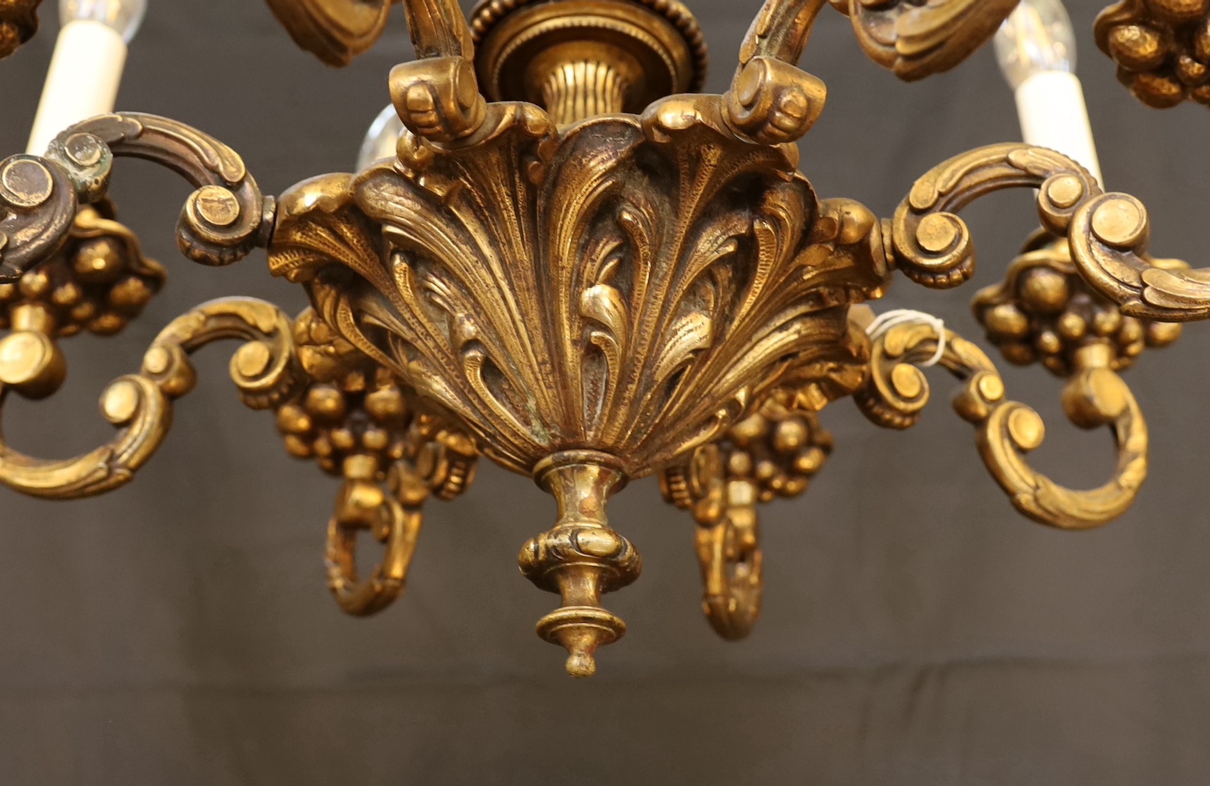 An early 20th Century Austrian bronze eight light chandelier, with scrolling branches and planished ball motifs, height 69cm. width 48cm